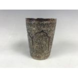 A white-metal beaker having Eastern influenced relief-moulded decoration, tests as silver, 69.1g