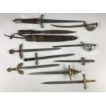 A quantity of miniature swords / paper knives, an ethnic African and one other dagger