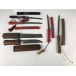 Four miniature Japanese swords / paper knives, together with a Japanese combination knife / chisel
