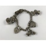 A silver charm bracelet with six charms, 38.6g