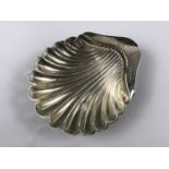 A George V silver butter dish in the form of a scallop shell, with glass liner, 52g weighable