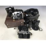 A cased Zenit 12 XP camera with two APS Optomax MX 3x lenses and a Helios 44m-4 lens together with