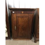 An early 19th Century mahogany cross-banded and marquetry-inlaid oak hanging corner cabinet