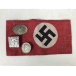 A reproduction German Third Reich NSDAP arm band and metal insignia etc
