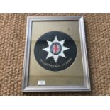 An early 20th Century Coldstream Guards embroidery, 25 cm diameter, framed and mounted, together