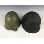 A Swiss Model 1918 steel helmet and a Cold War Soviet Bloc helmet