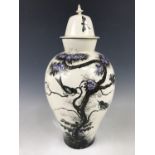 A large Victorian hand-enamelled oviform vase, decorated with birds perched on a blossoming tree (