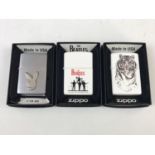 Three boxed Zippo lighters including The Beatles, Playboy and Tiger