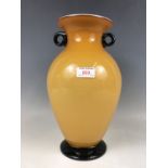 A large amber-flashed oviform glass vase, having black glass loop handles and a moulded foot, second