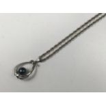 A vintage precious white-metal and black pearl pendant, of teardrop form, in an open ribboned