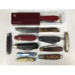Two Swiss army knives together with nine other pen knives