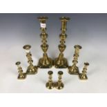 Four pairs of brass candlesticks