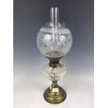 A Victorian oil lamp, having etched globe, facet-cut glass reservoir and brass base