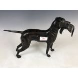 A bronzed sculpture of a dog, modelled as a retriever, in his mouth he grasps a game bird, 23 cm