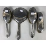 A four-piece silver hairbrush set