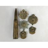 A trench art bullet lighter and several cap / collar badges