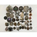 A quantity of military and other badges and brooches etc