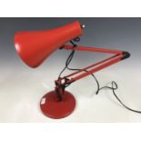 A contemporary red angle-poise lamp