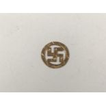 A 1920s yellow-metal pendant in the form of a swastika within an annulus, stamped 9ct, tested as