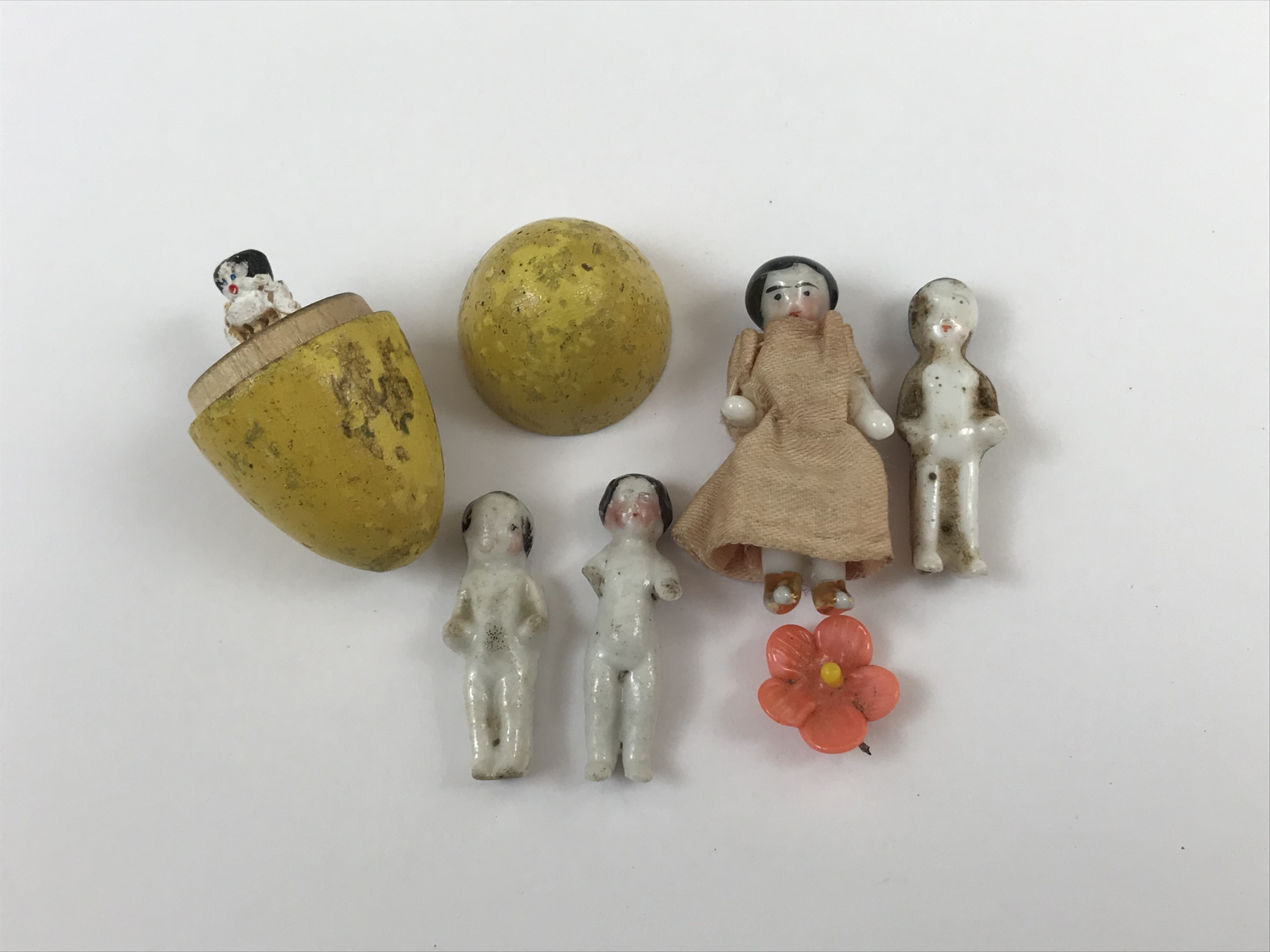 Three Victorian porcelain 'pudding' dolls, together with one further miniature porcelain doll and