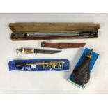 Two gun cleaning rods together with a hunting knife and a reproduction copper powder flask