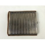 A silver cigarette case engraved with a monogram and the date "January 1914"