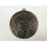 A cast brass relief moulded plaque depicting Stalin, 17 cm