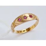 A Victorian 22ct gold and ruby three-stone dress ring, having three gypsy-set round cut stones set