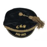 An early 20th Century sports cap, in black velvet with gilt bullion tassel, embroidered with the