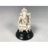 An early 20th Century Indian carved ivory figure of Ganesha, raised over an ebonised wooden