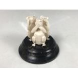An early 20th Century Indian carved ivory figure of the three wise monkeys, raised over an