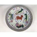 A Qing Chinese famille-rose charger, polychrome enamelled with Foo dogs chasing a ball with ribbons,