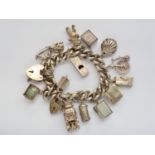 An Elizabeth II silver charm bracelet and charms, 117.4g