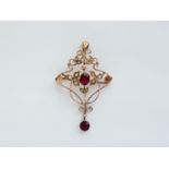 A Belle Epoque yellow-metal, garnet and seed pearl openwork pendant brooch, in a whiplash