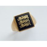 A gentleman's 9ct gold signet ring, the square face inset with a black glass emblazoned with three
