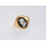 An antique yellow-metal and glass cameo signet ring, carved with the profile of a robed figure