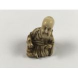 A Meiji Japanese carved ivory netsuke modelled as a sage, character marks to base, 3.5 cm high