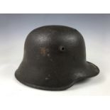 A relic Imperial German steel helmet exhibiting fractures