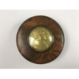 An early 19th Century French burr wood snuff box, the lid inset with a gilt metal plaque bearing a