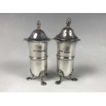 A pair of Edwardian silver pepperettes, each of elongated ovoid form with wavy everted rims, and