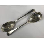 A pair of Edwardian silver Old English pattern berry spoons, the bowls repousse worked in patterns