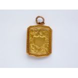 An early 20th Century lady's 9ct gold pendant locket, of shaped rectangular form, having scrolling