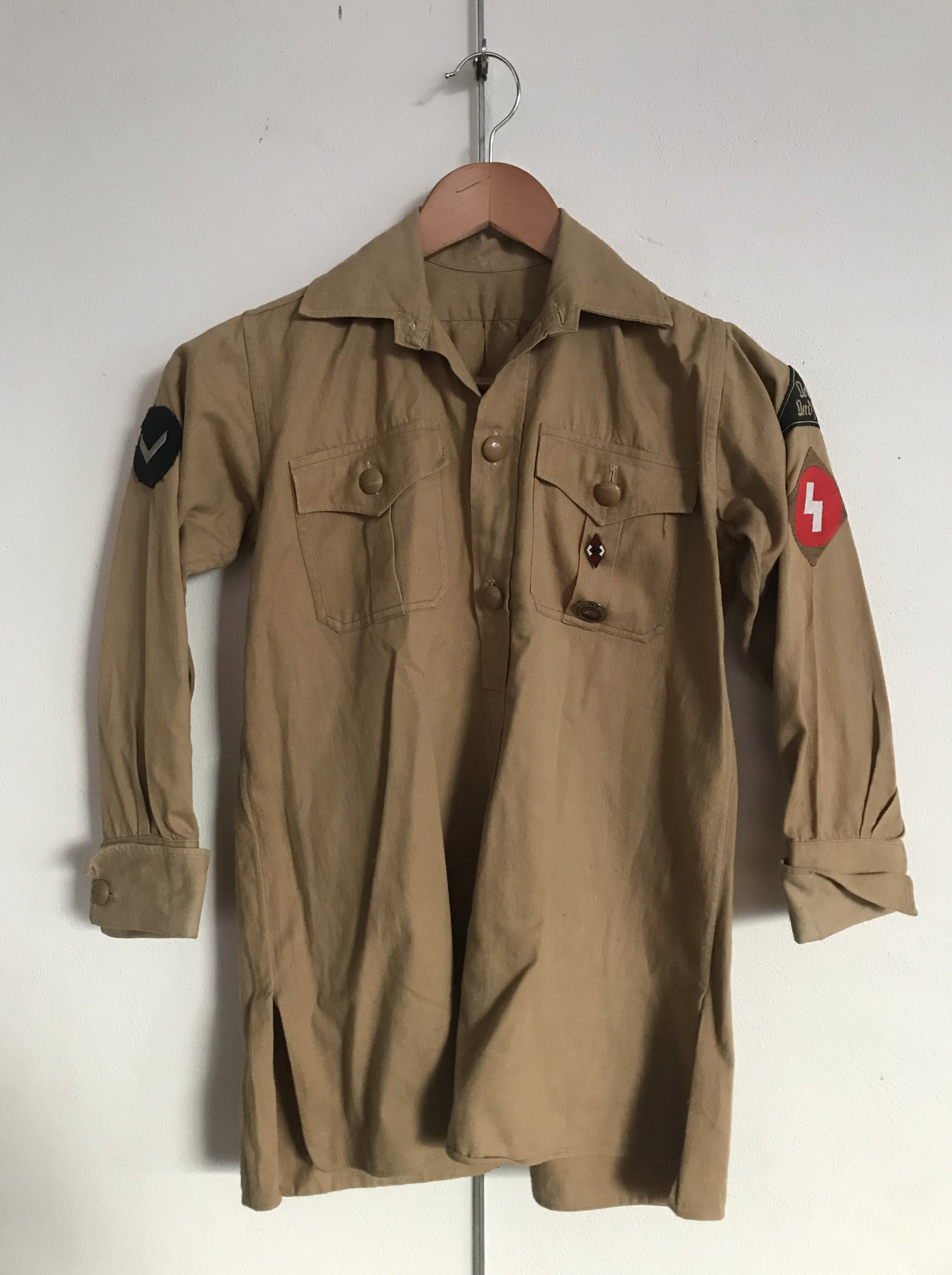 A Hitler Youth service shirt bearing Nord Nordsee district badge, Oberbann 1 and DJ-Hordenfuhrer