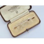 An Art Deco diamond solitaire bar brooch, the brilliant-cut stone of approximately .10ct, crown