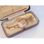 A 1930s lady's 9ct gold wristlet watch, having circular dial with gilt flower head, silvered chapter