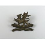 An 11th (Lonsdale) Battalion Border Regiment brass cap badge, bearing Gaunt plaque