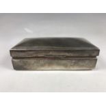 An Edwardian silver table cigarette box, of rectangular section with a domed cover, marks rubbed,