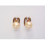 A pair of yellow-metal and pearl ear clips, pearls each approximately 8.5 mm, tests as gold