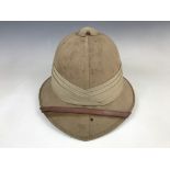 A 1941 British Army Wolseley pattern tropical helmet and cover, each bearing the details of their