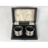 A cased pair of George VI silver napkins, having engine turned banded decoration, John Rose,